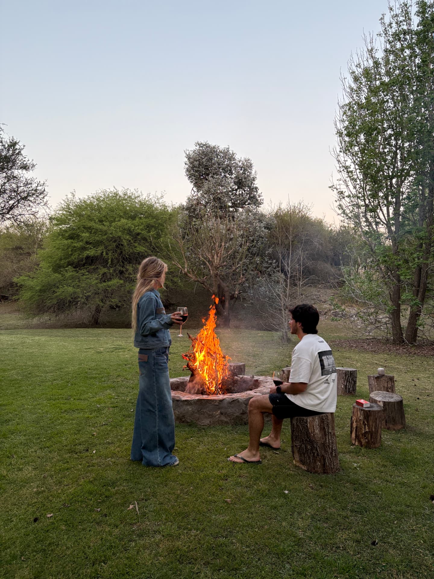 Pareja junto a un fogón al atardecer
