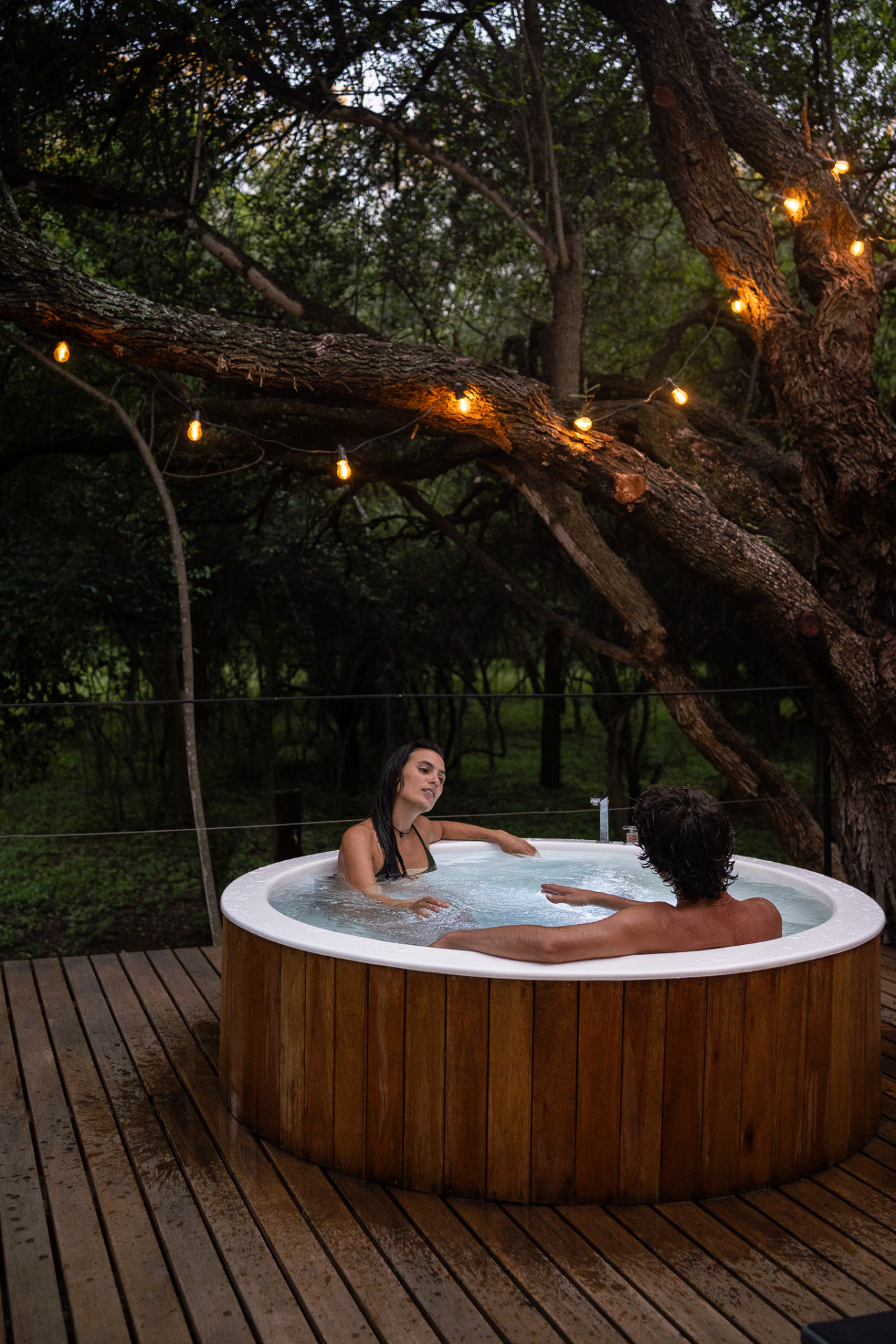 Pareja disfrutando un jacuzzi entre los árboles